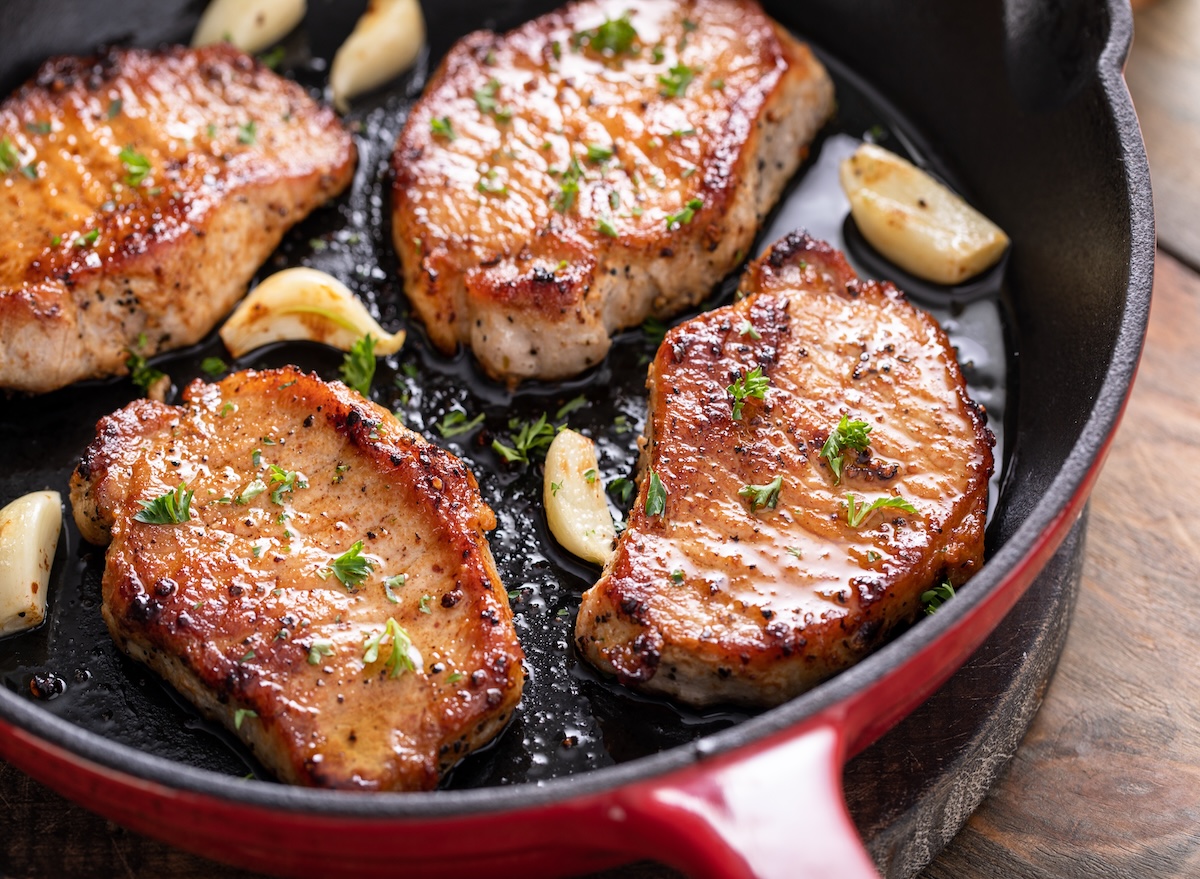 Pork,Chops,Cooked,With,Garlic,In,A,Cast,Iron,Pan